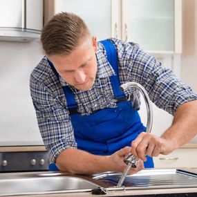 Fontanero arreglando llave de cocina