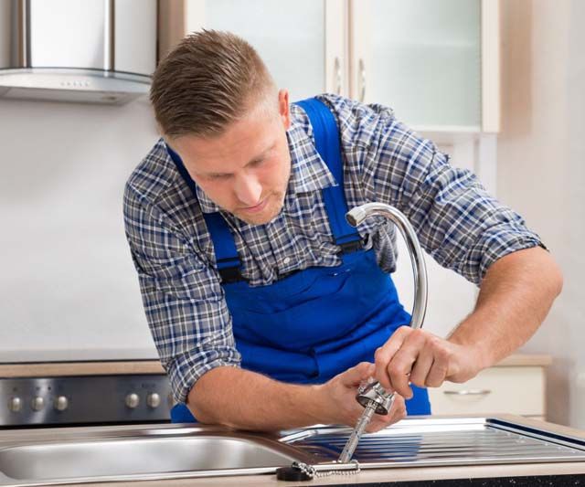 Fontanero arreglando llave de cocina